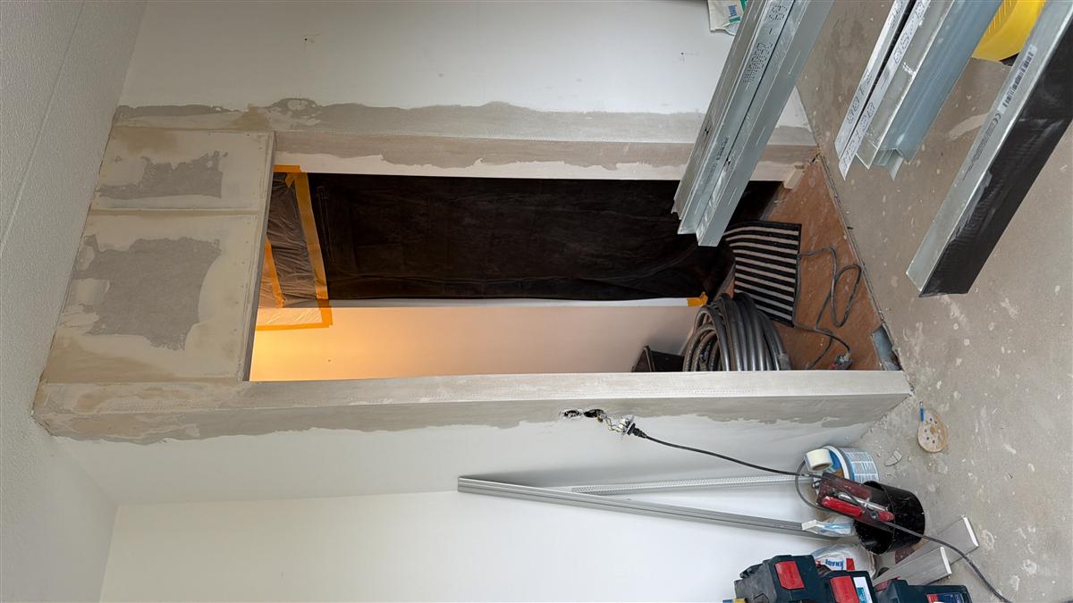 Vorbereiteter Wanddurchbruch im Trockenbau mit bereitgelegten Metallprofilen und Werkzeug.