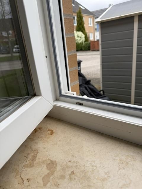 Fenster mit Rahmen und Fensterbank, Zustand vor Wartung und Abdichtung.