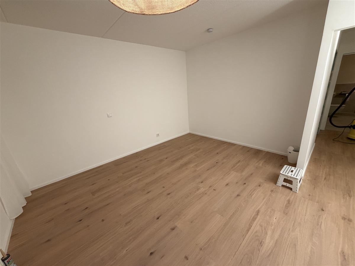 Helles Laminat frisch verlegt in einem Wohnzimmer, saubere Verarbeitung bis zur Wand.