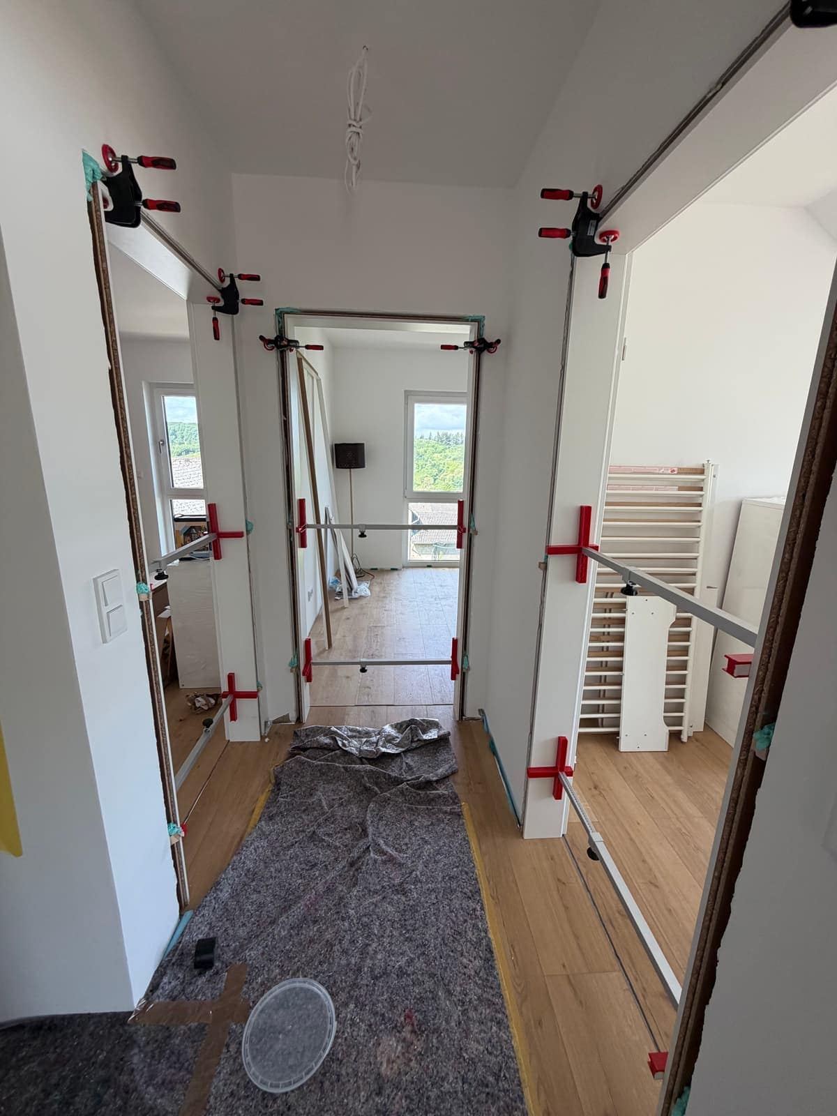 Mehrere Innentüren im Flur gleichzeitig in Montage, Zargen mit Spannern fixiert.